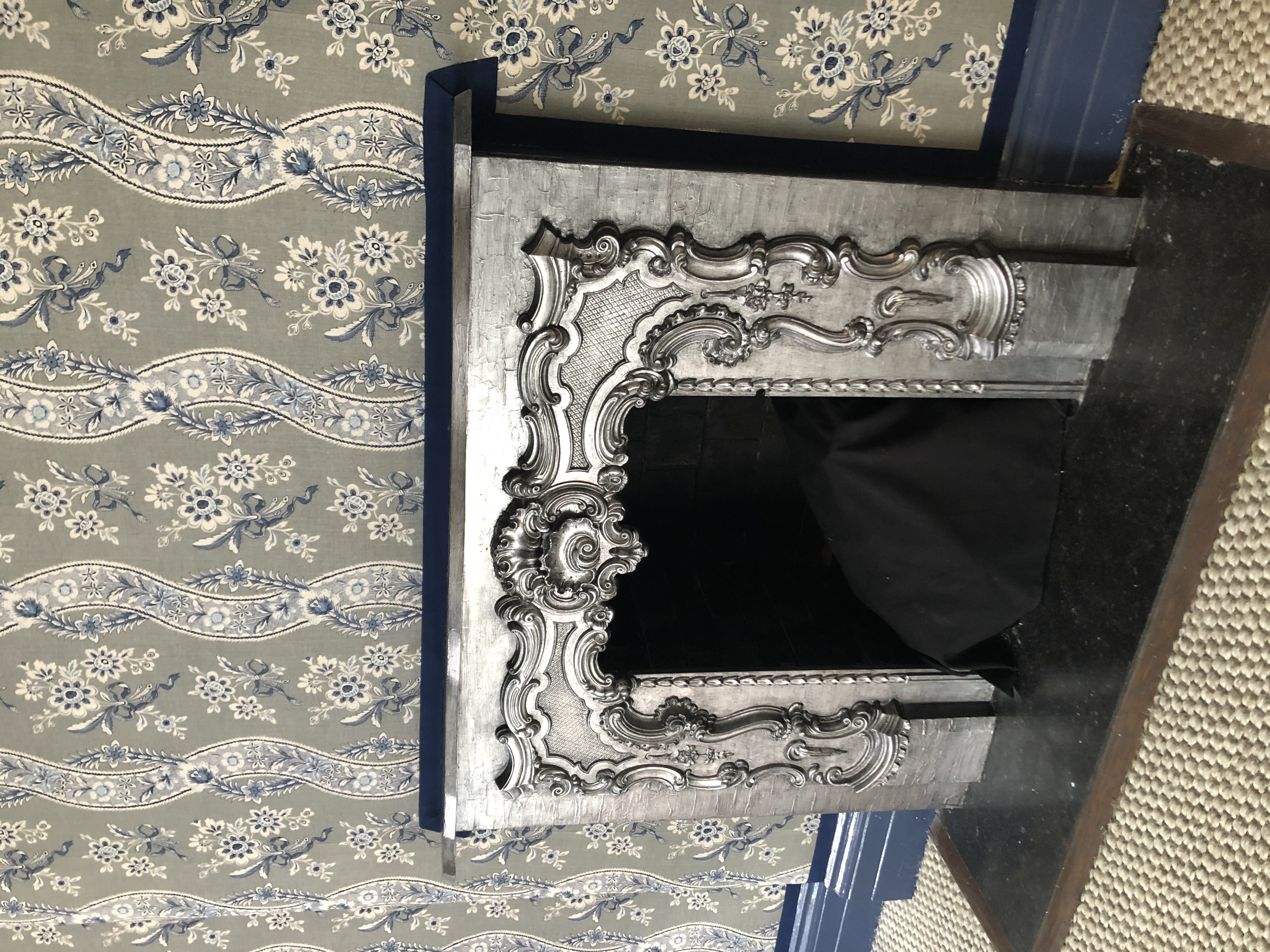Ornate fireplace with a layered silver finish